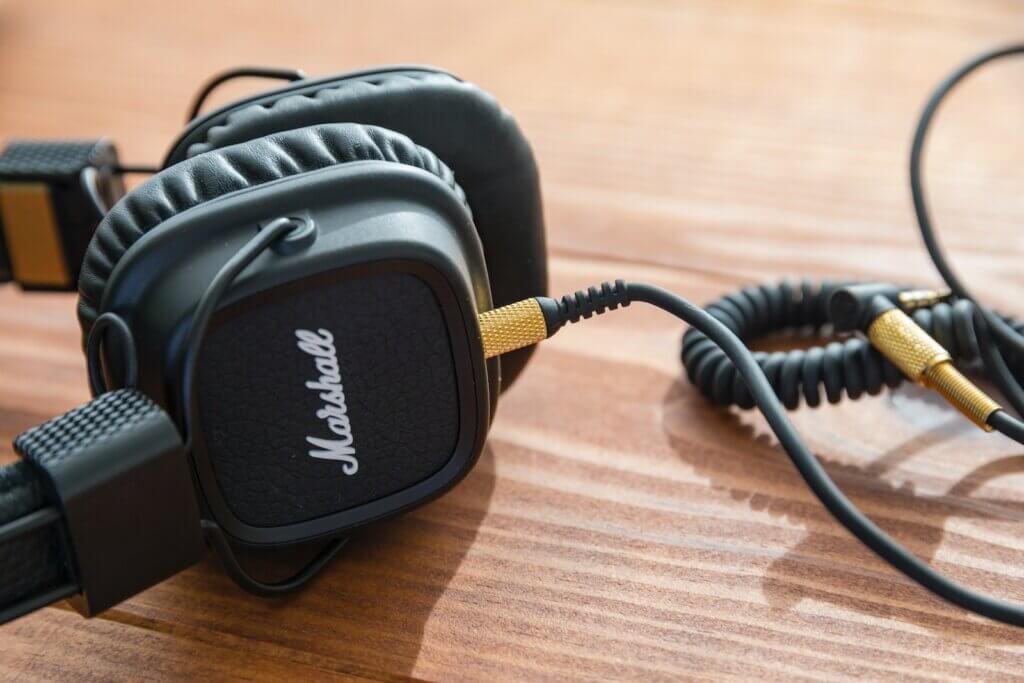 black Marshall headphones on wooden table